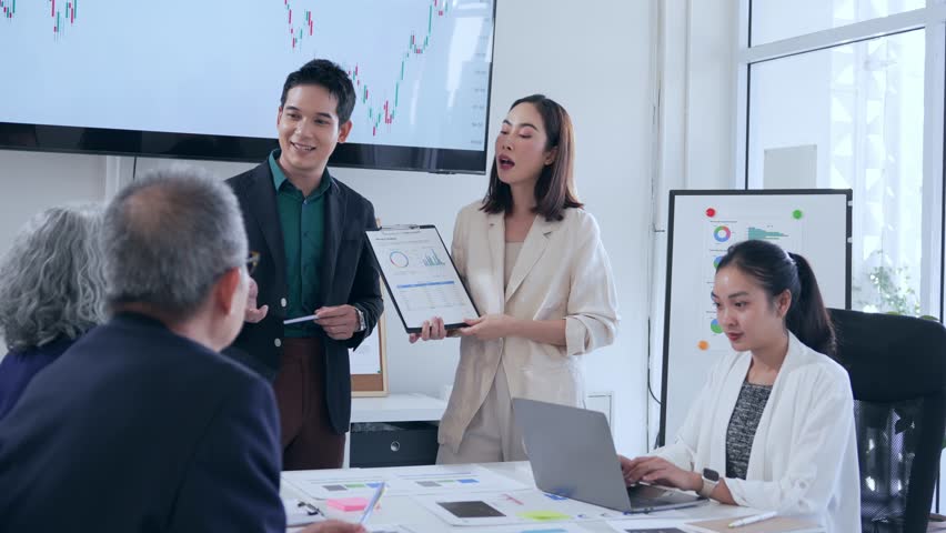 Asian businesspeople discussing financial charts and data analysis during a productive meeting in a modern office, collaborating on important business strategies and goals - Powered by Shutterstock - Get 15% off with code: PIKWIZARD15