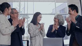 Professional diverse team analyzing data on laptop, celebrating collaborative project success with enthusiastic group applause in bright modern office setting - Powered by Shutterstock - Get 15% off with code: PIKWIZARD15