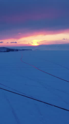 Aerial view of frozen lake Baikal at sunset in winter season of Siberia, Russia. Vertical video
