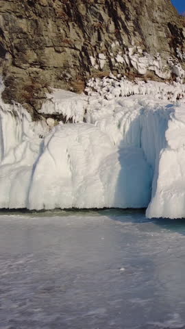 Around view of frozen Lake Baikal, Olkhon Island, Rock cape. Siberia, Russia. Vertical video