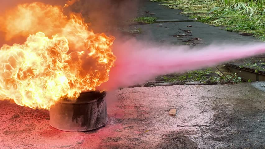 Pink powder fire extinguisher spray to extinguish fire