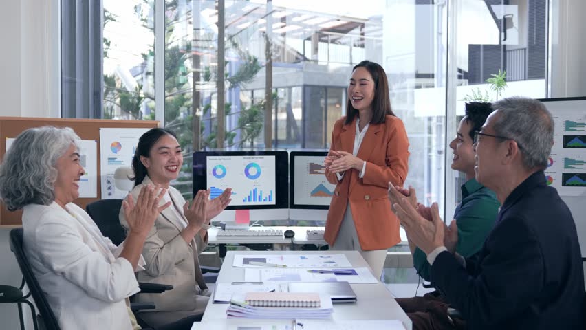 Professional business team celebrating collaborative success, sharing high fives and applause after impressing colleagues with compelling presentation in modern workplace setting