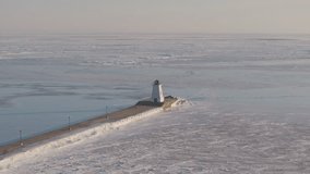 Frozen Lake Erie with a lighthouse at the end of a snow-covered pier, serene winter scene - Powered by Shutterstock - Get 15% off with code: PIKWIZARD15