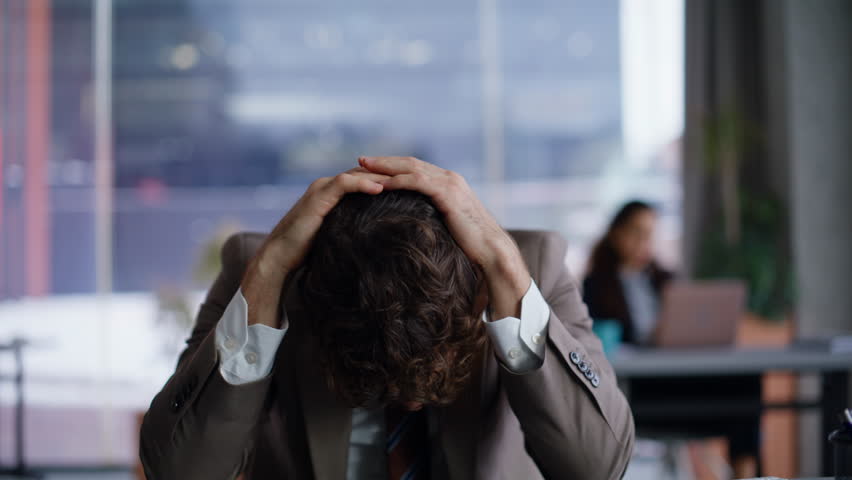 Nervous loser reacting fail working laptop at creative agency closeup. Disappointed worried businessman touching head closing computer at modern coworking interior. Upset professional having problems