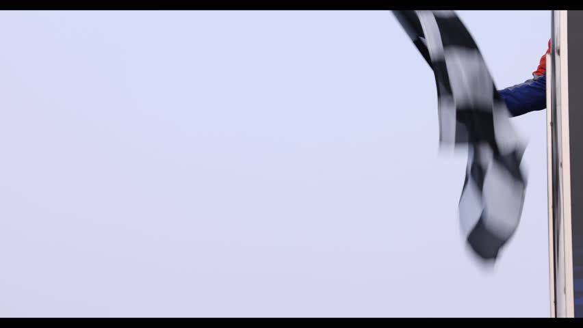 Man holding and waving checkered race flag on finish podium, Finish line and checkered flag, Race flag at the finish line on a race track, Victory achievement success motorsport.