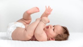Delicate baby lying on back, playfully reaching and grabbing bare feet while wearing diaper, nestled on pristine white background - Powered by Shutterstock - Get 15% off with code: PIKWIZARD15
