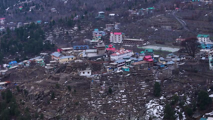Aerial drone shot showcasing the stunning beauty of Kalpa, with its traditional wooden houses set against the majestic Kinner Kailash range.