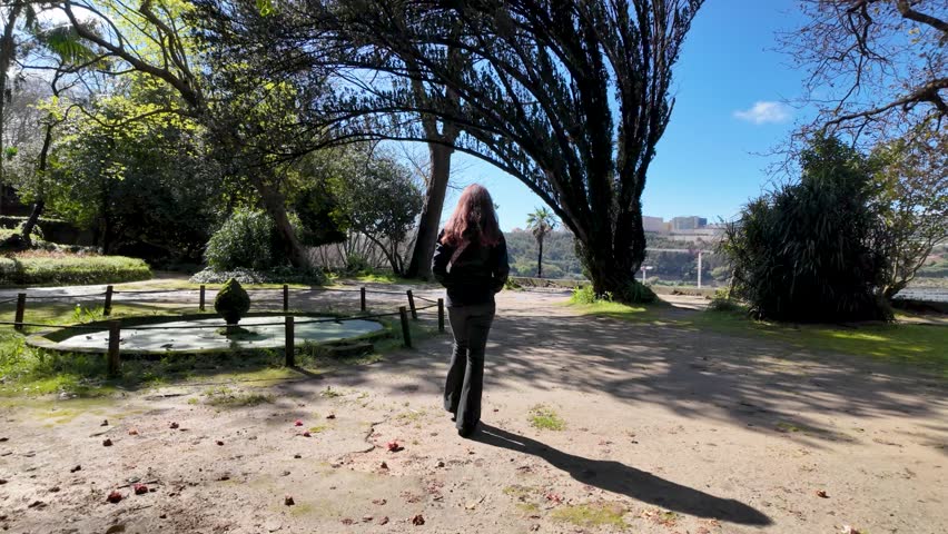 Slowmotion of girl walking in Porto’s Jardins do Palácio on sunny day