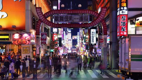 TOKYO - DECEMBER 15: Pedestrians pass through the Kabuki-cho nightlife district december 15, 2012 in Tokyo, JP. The area is a nightlife district known as Sleepless Town.