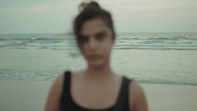 A blurred silhouette of a woman in black stands against the waves at Utorda Beach, South Goa, during dusk - Powered by Shutterstock - Get 15% off with code: PIKWIZARD15