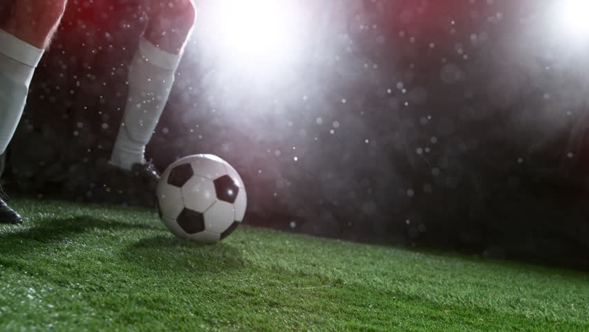 Close-up of Football Player Kicking Soccer Ball, Rainy Weather, Fog in Background. Super Slow Motion at 1000 fps. Filmed on High Speed Cinematic Camera at 1000 fps.
