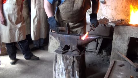Blacksmith is hammering a red-hot piece of iron
