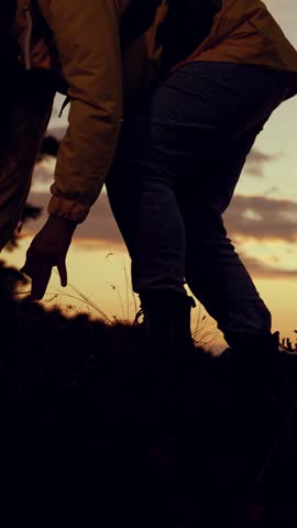Silhouette of woman climber with backpack against sky, climbing to top of hill. Victory success in business. Hiker. Traveler woman climbs to top of rock. Striving for success, achievement in business