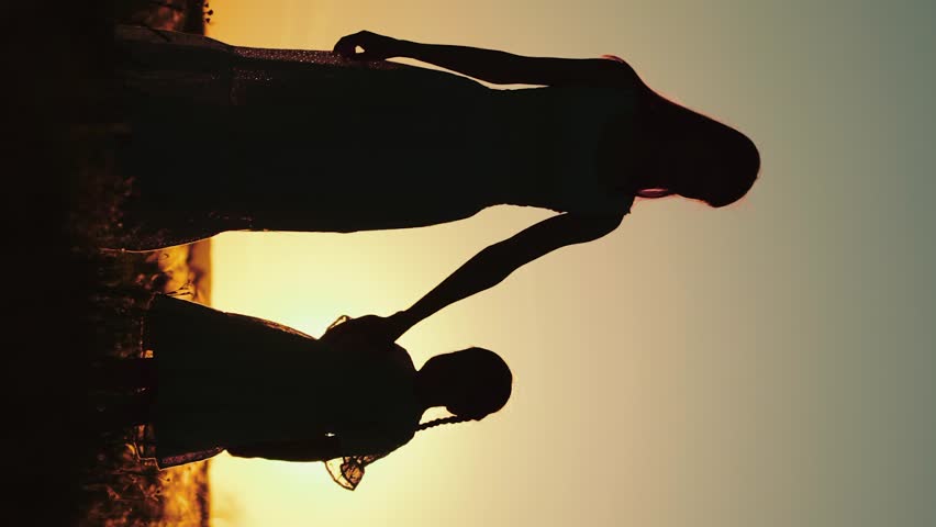 silhouette happy family, mother holding hand child kid daughter girl sunset, mother and child silhouette, shadowed family bonding, maternal affection, child learning walk, teaching child, family