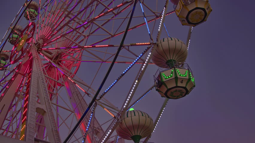 Ferris Wheel Turns Colorfully at the Amusement Park at Dusk Footage.