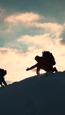 Travelers climb one after another on rock Climbers silhouettes stretch their hands to each other climbing to top of hill. Teamwork of business people. Go towards your goal. Team of businessmen victory