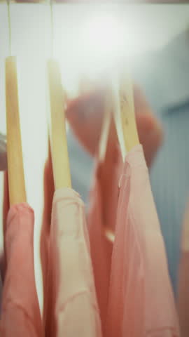 A woman explores a stylish boutique, carefully selecting clothes that reflect her unique fashion sense. The atmosphere is vibrant, filled with colorful garments that spark her creativity