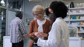 Friendly pharmacist assisting a mature customer with her prescription, providing helpful advice and information - Powered by Shutterstock - Get 15% off with code: PIKWIZARD15