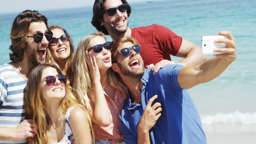 Group of friends at beach with colorful SALE animation overlay. Vacation, summertime, discount, friendship, leisure, ocean