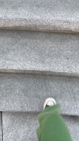 POV top view legs in black and white canvas shoes under green pants walking up the stairs.