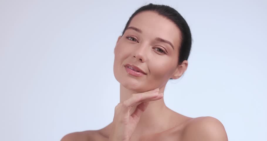 A graceful young woman poses with natural makeup and flawless skin. Perfect for beauty, health, skincare, anti-aging or spa-themed advertisement and editorial use. 