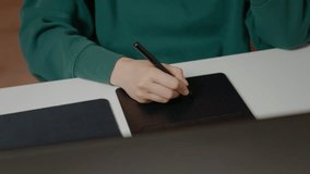 Graphic designer focuses on creating illustrations using a pen display and laptop in a cozy home office setting. The process showcases digital artistry and technology. - Powered by Shutterstock - Get 15% off with code: PIKWIZARD15