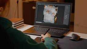 Professional photo editor working diligently on laptop, using graphics tablet for precise image retouching in cozy home studio workspace during evening hours - Powered by Shutterstock - Get 15% off with code: PIKWIZARD15