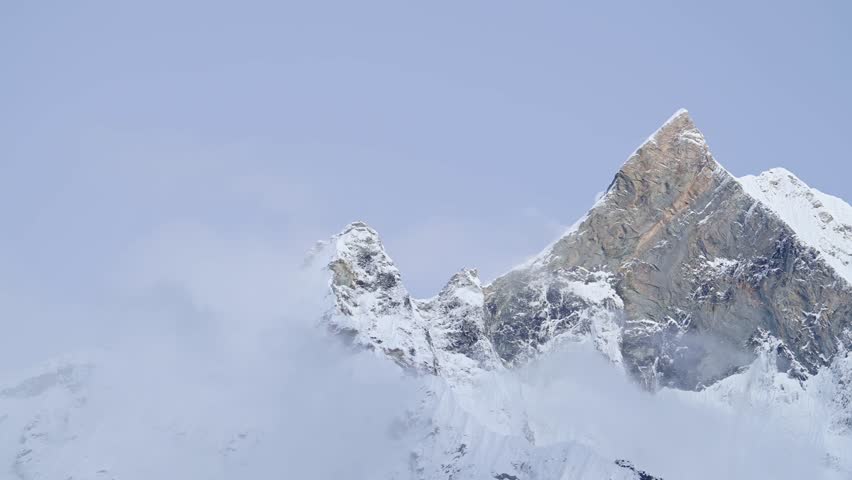 Dramatic Mountain Top in Clouds in Nepal, High Snowy Snowcapped Winter Himalayas Mountains Summit Covered in Snow, Atmospheric Beautiful Jagged Rugged Mountain Peaks Close Up