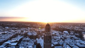 Zwolle Peperbus church tower rising up over the snow covered rooftops in the downtown district aerial drone view during a cold winter sunrise. - Powered by Shutterstock - Get 15% off with code: PIKWIZARD15