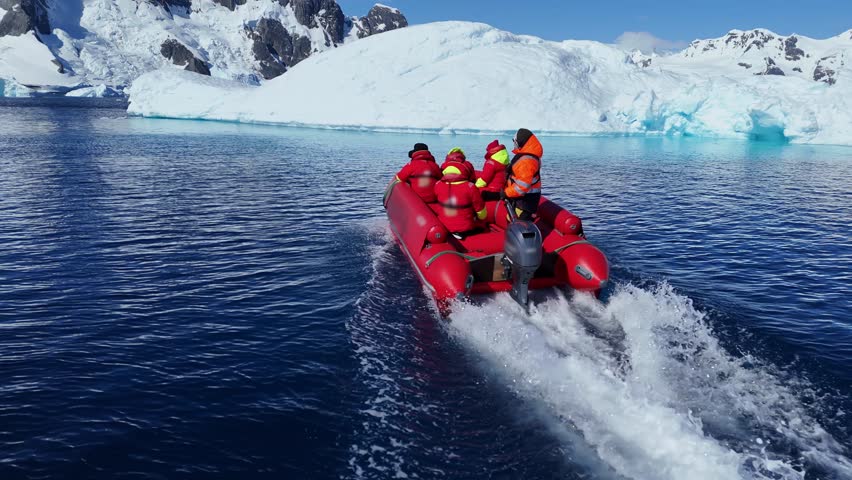 Antarctica icy landscape expedition group tourist traveler people man at cruise red boat ship winter Arctic snow mountains Iceberg glacier nature cold water. Scientist Tourism travel. Aerial drone 