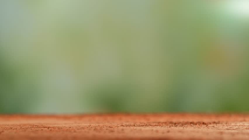 Super Slow Motion Detail Shot of Tennis Ball Hitting a Clay Court . Filmed on High Speed Cinematic Camera at 1000 fps