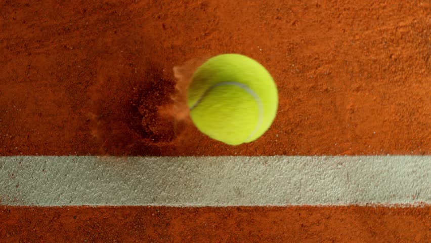 Super Slow Motion Detail Shot of Tennis Ball Hitting a Clay Court . Filmed on High Speed Cinematic Camera at 1000 fps