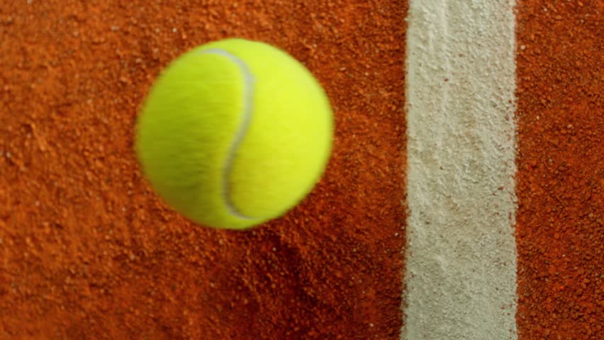 Super Slow Motion Detail Shot of Tennis Ball Hitting a Clay Court . Filmed on High Speed Cinematic Camera at 1000 fps