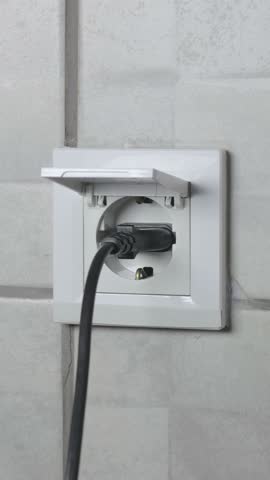 Vertical video of man is closing and outputting outlet plug in safety waterproof electricity switch socket with cover in bathroom. Close up, 4k footage.