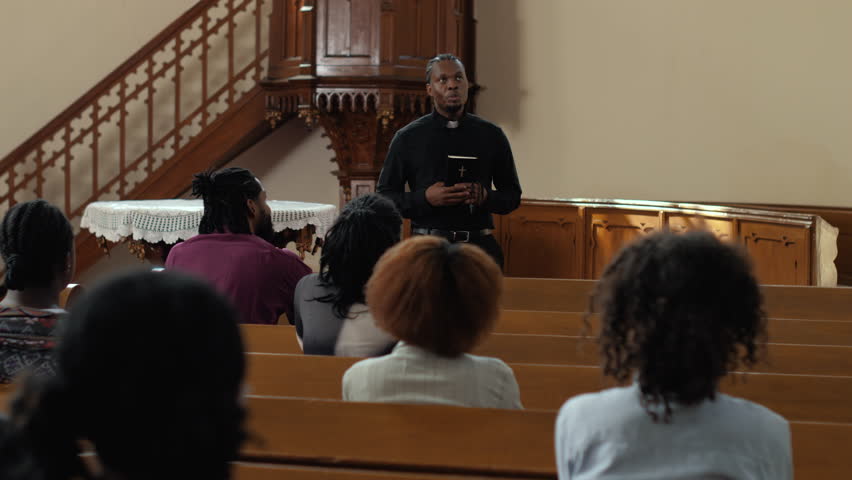 Religious congregation attentively listening to priest delivering passionate sermon inside traditional church interior, capturing spiritual moment of faith and community connection