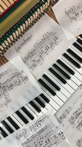 music studio scene - sheets of music notes among autumn maple leaves lie on the piano keyboard, ukulele, microphone