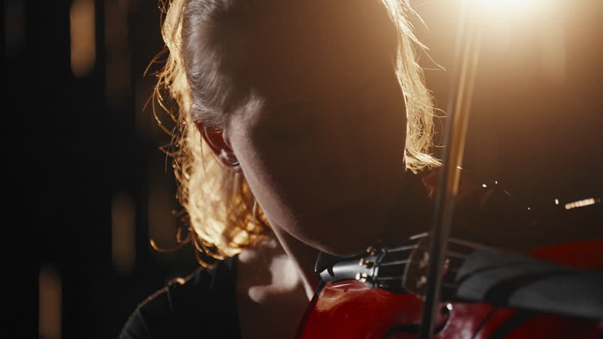 Female violinist playing in rain in night, close up portrait of talented women. Enjoy classical music, listening to fabulous hypnotic sounds of old violin, talent and inspiration, be lonely and sad