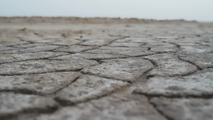 Dry and cracked Sahara desert ground scene under a clear sky