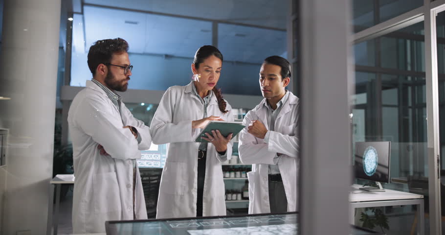 Scientist, people and discussion with tablet in laboratory for pharmaceutical planning, medical research and feedback. Night, teamwork and clinical analysis of science data and experiment results