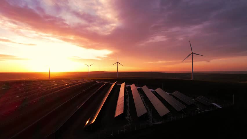 Windmill turbines generating green energy electric. Green energy reduce carbon emissions and makes earth cleaner and more ecological. Solar panels park and wind turbines at sunset.