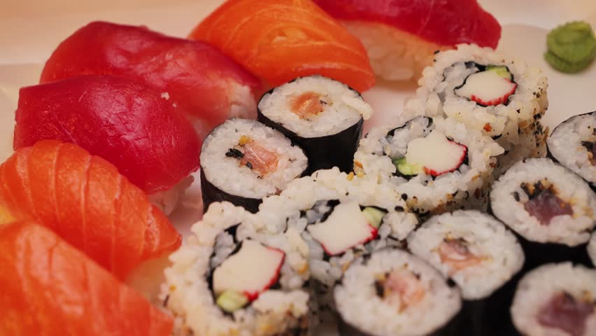 A large plate of rolls and sushi with various fish fillings in a Japanese restaurant.