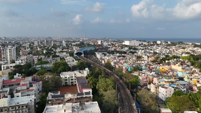 Aerial footage of the evolving Chennai cityscape with local metro train station in the middle of buildings