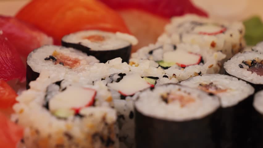 A large plate of rolls and sushi with various fish fillings in a Japanese restaurant.
