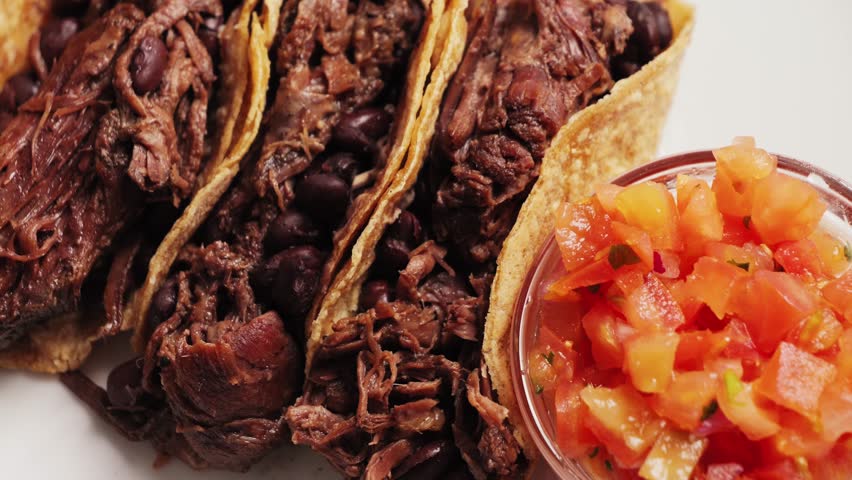 Traditional Mexican food tacos with pulled pork, beans served with Mexican sauce Pico De Gallo, spicy hot sauce made from diced tomatoes, onions and jalapeno peppers.