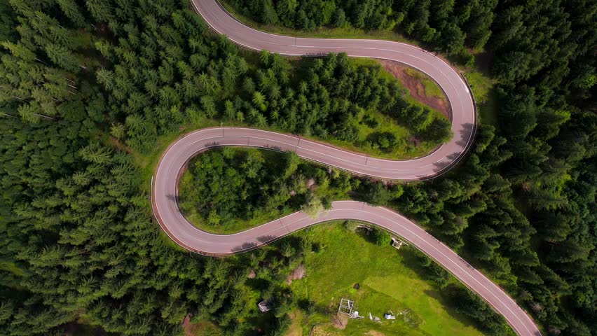 Top view of the road passing through the mountain and green forest. Curve asphalt road on mountain forest summer. 