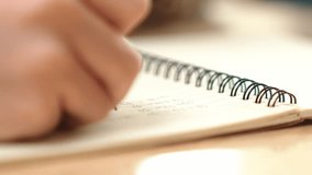 Close up of child hand taking a note or writing a letter at classroom. Happy student hands hold pen at book or doing homework or doing test at elementary school. Focus on hand. Education. Pedagogy. - Powered by Shutterstock - Get 15% off with code: PIKWIZARD15