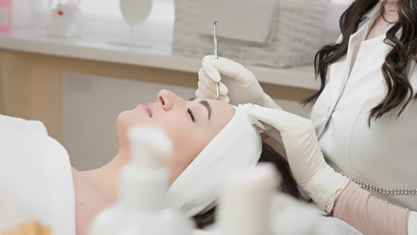 A skilled cosmetologist is performing a detailed cosmetic procedure on a clients face using specialized tools in a serene spalike environment that promotes relaxation and wellness
