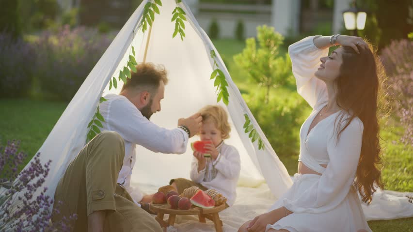 Family picnic with child in cozy garden. Concept of outdoor recreation.