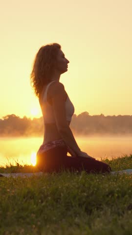 A woman is practicing yoga with grace and elegance at sunset, embodying a deep sense of peace and balance while harmonizing her spirit with the breathtaking beauty of nature as summer approaches