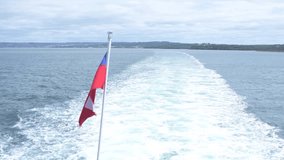 Chilean flag waving in the wind in foreground on the stern of a ship - Powered by Shutterstock - Get 15% off with code: PIKWIZARD15